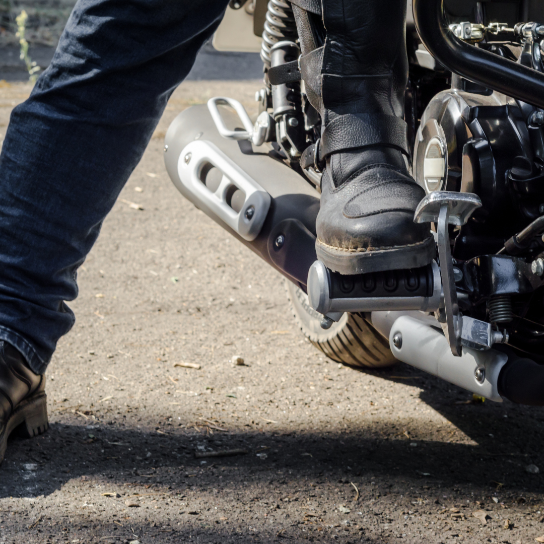 A person riding a motorcycle wearing shoes.