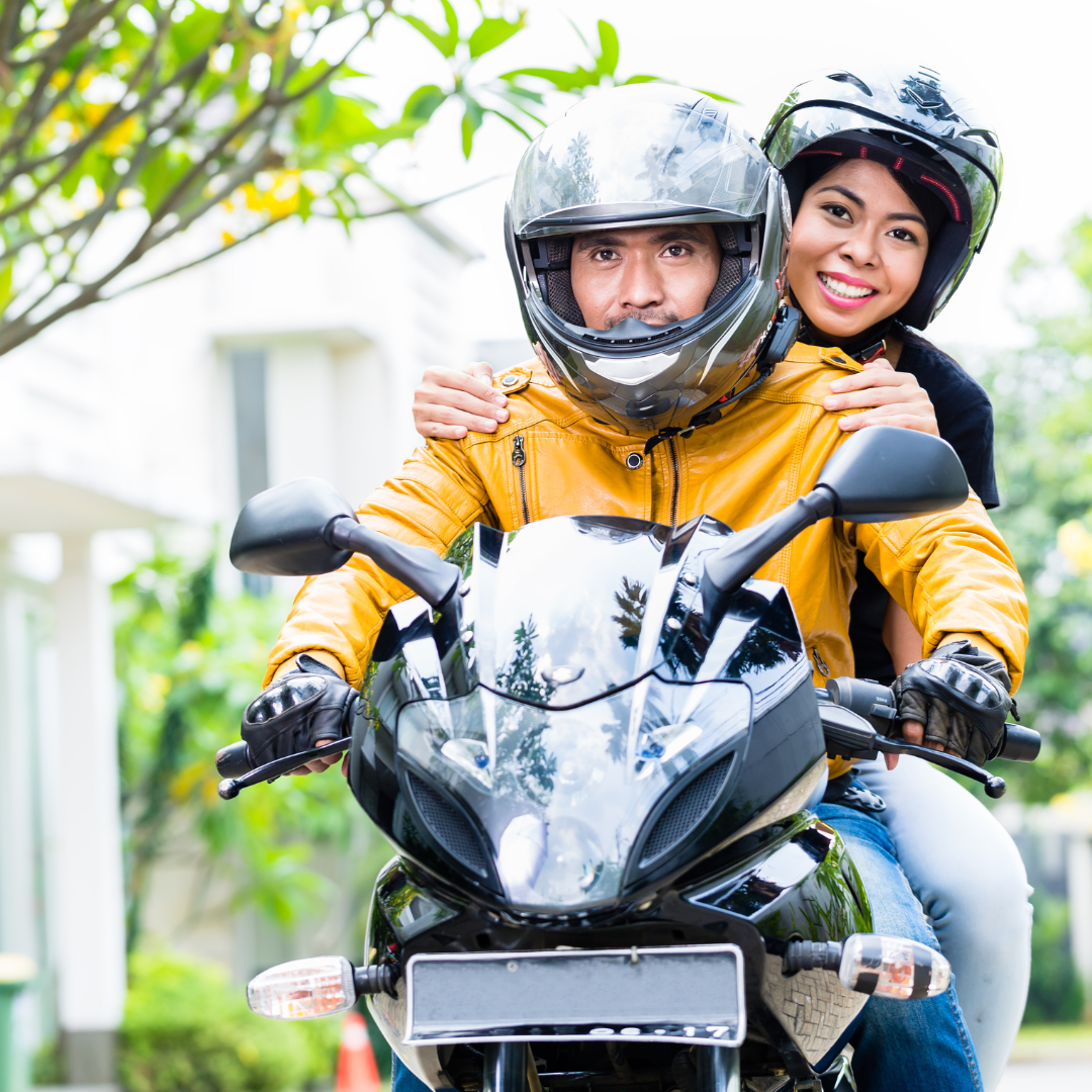 A man and woman riding a motorcycle with perfectly fitting helmets.