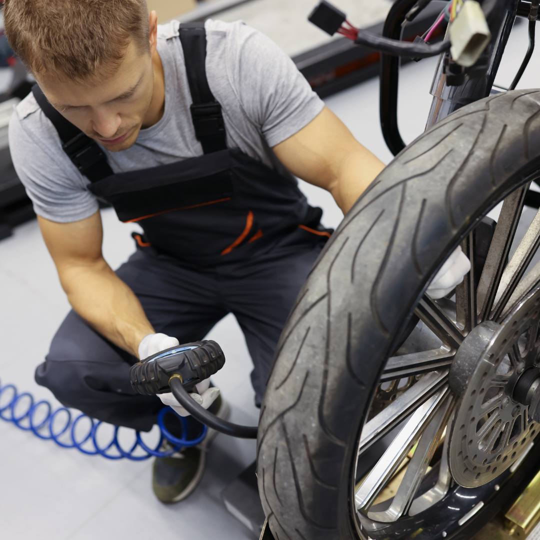 A man efficiently inflating a motorcycle tire using the best tire pump.