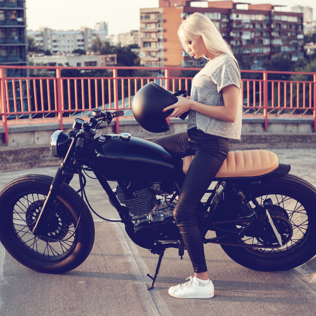 A stylish woman confidently sitting on a comfortable motorcycle in her chic motorcycle outfit.