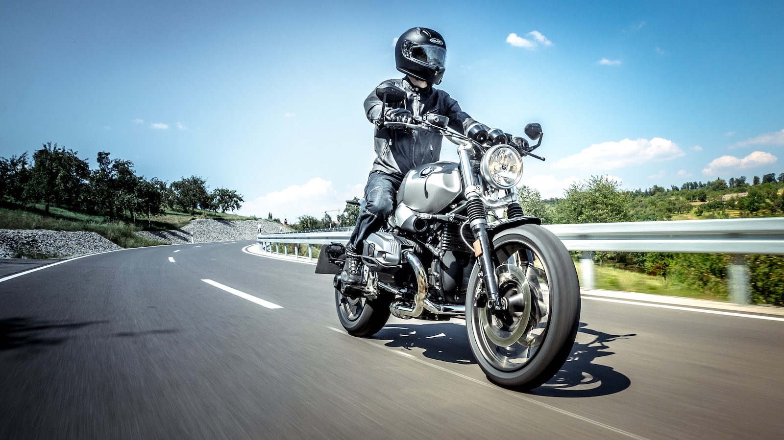 man in black helmet riding on black motorcycle on road during daytime