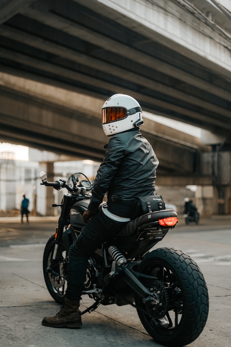 man in black leather jacket riding black motorcycle